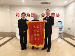 1月3日，一名八旬老人将一面印有“公正执法、热情服务”的锦旗送到了三元法院法官胡江平、书记员颜楚君手中。